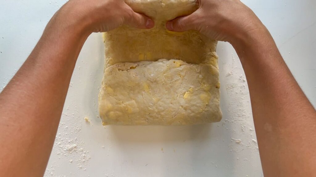 Hands folding pastry dough